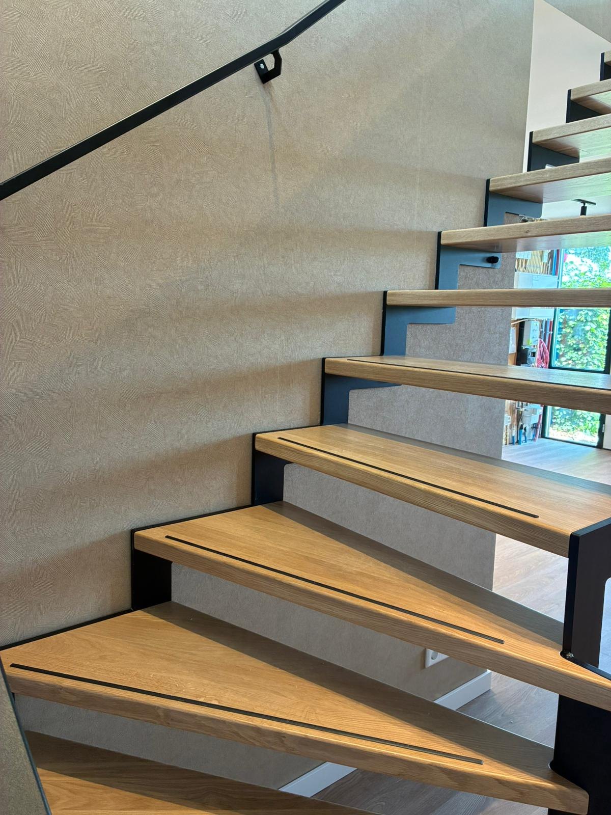 Detail van de eiken treden met zwarte antislip-strips en zwarte stalen boom, engineering door Previn Engineering